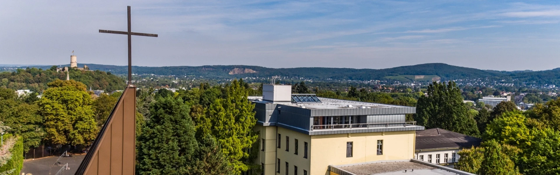 Aloisiuskolleg mit Kreuz auf Kirche