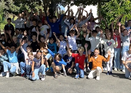 Viele Schülerinnen und Schüler stehen zusammen für ein Gruppenfoto